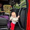Izzahbella is registered to the contest to win money with this photo: baby, child, toddler, smiling, standing, vehicle, truck, car_interior, red_vehicle, grab_bar, seat, blanket, purple_blanket, sweater, red_pants, boots, outdoor, trees, family, portrait