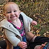 adult, arms, autumn, baby, blue_eyes, child, clothing, forest, grass, happy, infant, jacket, leaves, nature, outdoor, pink, polka_dot, portrait, sitting, smiling