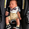 baby, infant, car_seat, sleeping, bow_tie, suspenders, white_shirt, shorts, sneakers, footwear, black, child, cute, resting, indoors, clothing, fashion, portrait, seatbelt, adorable