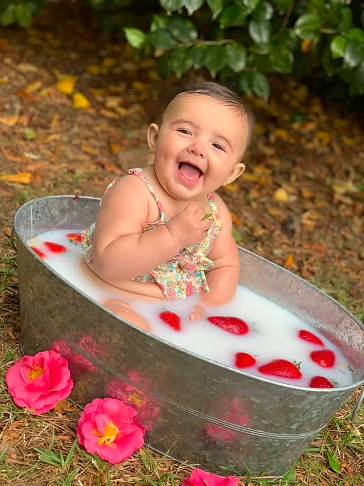 Miylah is registered to the contest to win money with this photo: baby, botany, child, dress, facial_expression, flower, fun, grass, happy, leaf, leisure, lip, people_in_nature, person, petal, pink, plant, smile, summer, toddler