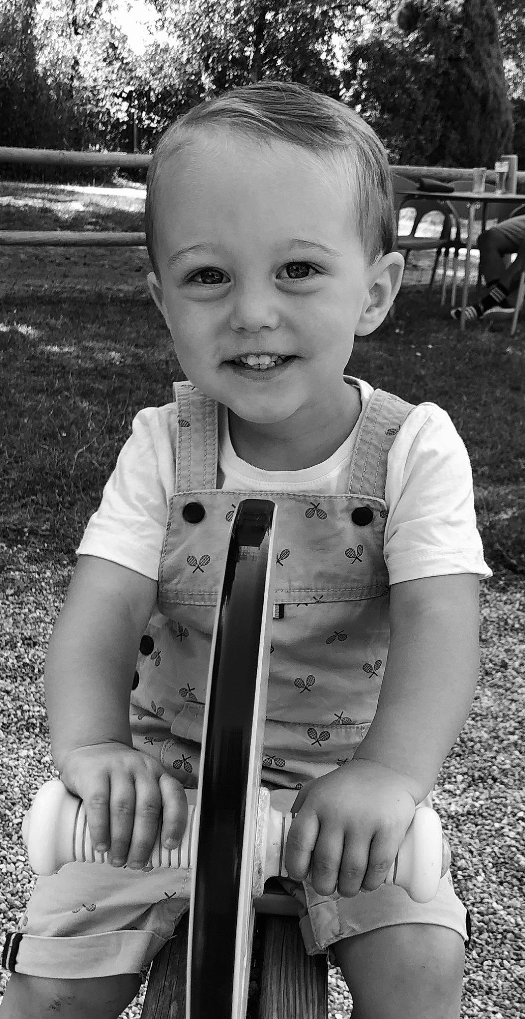 Tilio a rejoint le concours — aidez-le/la à gagner de superbes lots ! arm, baby_toddler_clothing, black, black_and_white, face, facial_expression, flash_photography, grass, hairstyle, hand, happy, human, joy, person, photograph, skin, sleeve, smile, standing, style