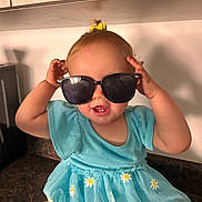 Wrenzie joined the competition — help win amazing prizes! toddler, child, sunglasses, blue_dress, daisy_pattern, kitchen_counter, smile, cheeky, yellow_bow, baby, cute, indoor, person, happy, playful, portrait, young_child, fashion, accessory, casual