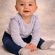 Nora participe au concours pour gagner de l'argent avec cette photo : baby, infant, child, smile, portrait, studio, sitting, hands, socks, ruffle, long_sleeve, cute, happy, eyes, cheeks, floor, soft_background, clothing, toddler, person