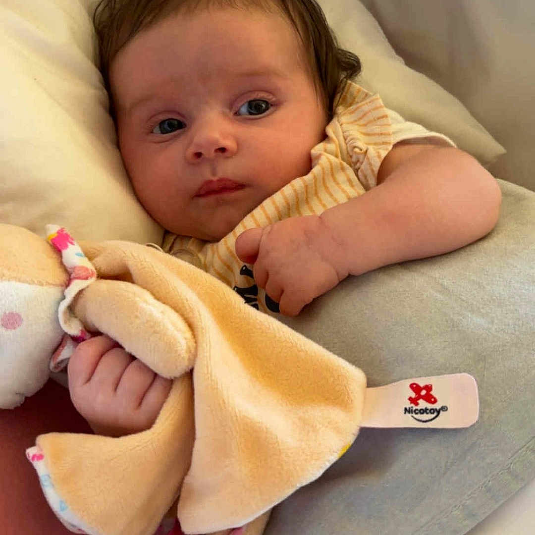 Youhanna participe au concours pour gagner de l'argent avec cette photo : baby, bedding, blanket, child, clothing, comfort, cozy, cute, face, hand, indoor, infant, lying_down, newborn, person, pillow, plush_toy, resting, sleepy, soft_toy