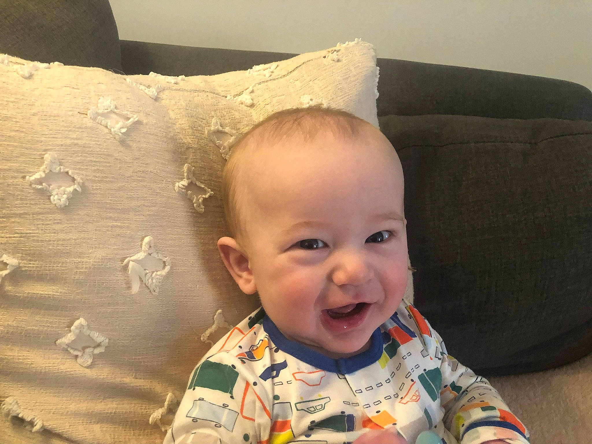 Luke is registered to the contest to win money with this photo: baby, baby_toddler_clothing, cheek, child, clothing, comfort, couch, eye, happy, head, iris, nose, person, pillow, sitting, skin, sleeve, smile, textile, toddler