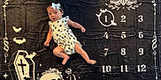 Aneira is registered to the contest to win money with this photo: baby, infant, romper, headband, bow, monthly_milestone, blanket, skull, bats, coffin, numbers, months, black_background, white_print, flowers, crystals, gothic_theme, cute, surprised, lying_down