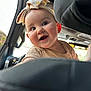 baby, child, smile, headband, car_interior, seat, window, light, happy, cute, infant, face, clothing, earrings, portrait, young, people, vehicle, travel, joy