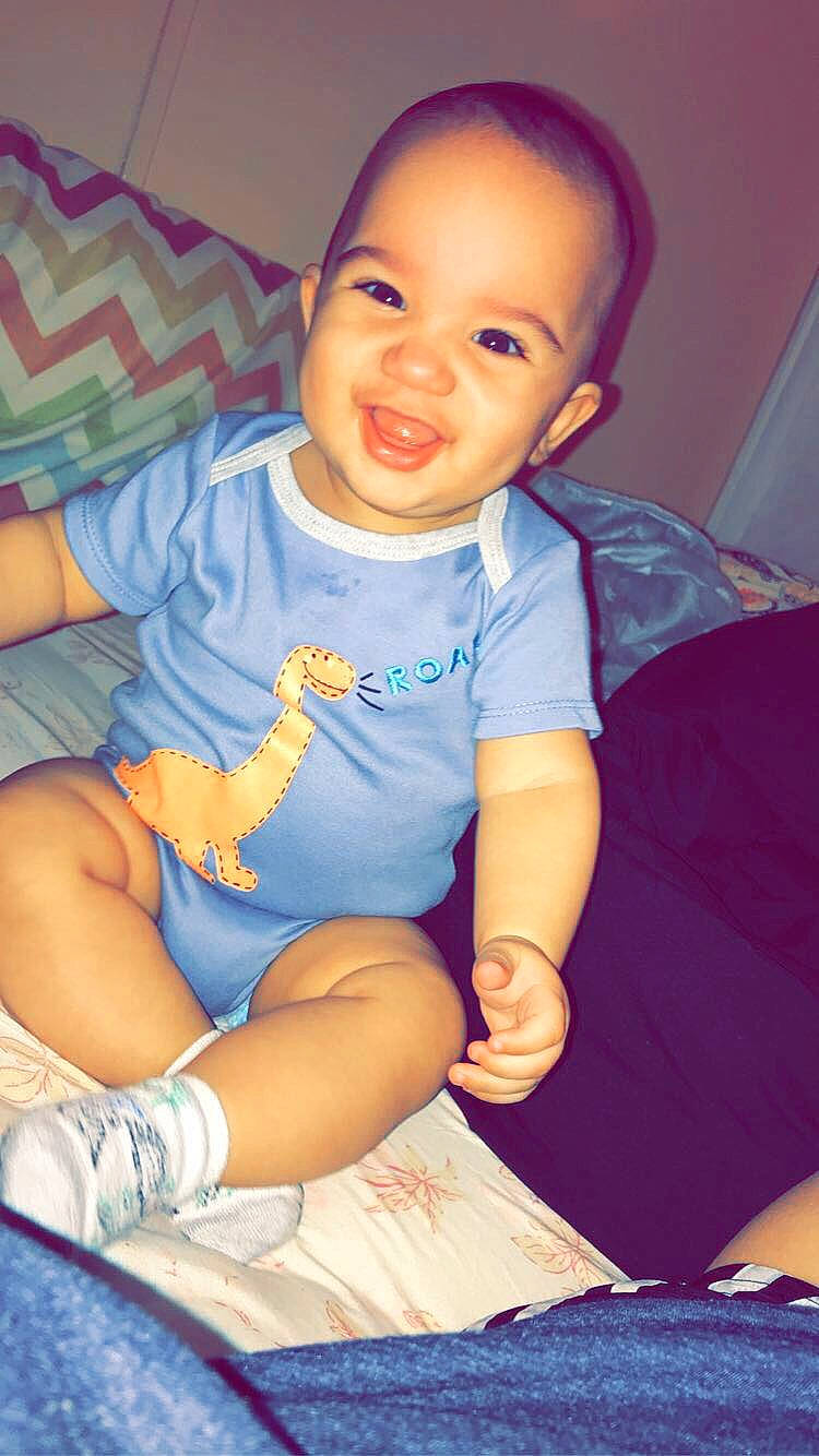 Keenan is registered to the contest to win money with this photo: arm, baby_toddler_clothing, cheek, chin, eye, face, finger, hairstyle, hand, happy, head, iris, mouth, muscle, neck, nose, person, purple, skin, sleeve