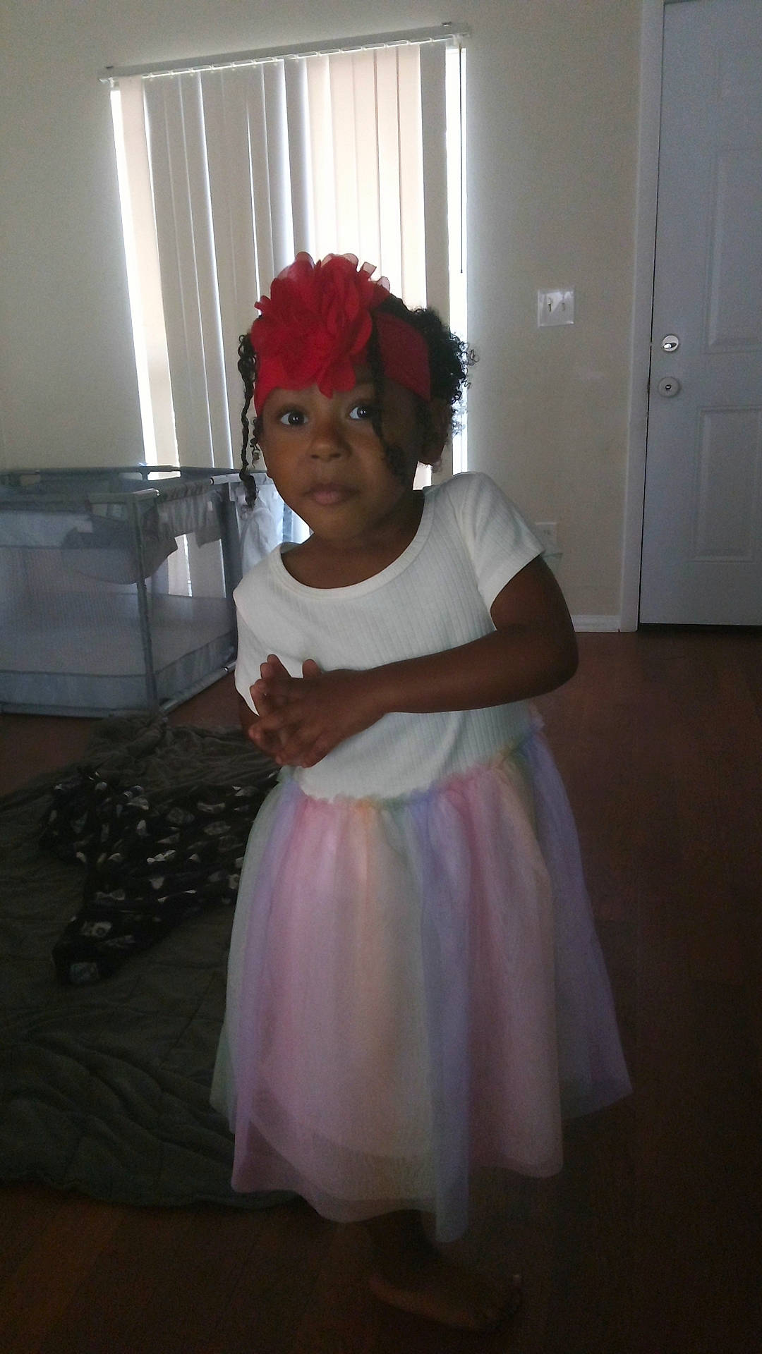 Ariel is registered to the contest to win money with this photo: baby_toddler_clothing, child, day_dress, door, dress, event, eye, fashion_accessory, fashion_design, flooring, flower, fun, hat, headpiece, headwear, human_body, magenta, person, sitting, toddler