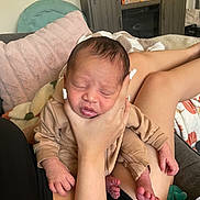 Jayce is registered to the contest to win money with this photo: newborn, baby, infant, sleeping, hand, couch, pillow, blanket, home_interior, person, legs, nail_polish, clothing, relaxation, comfort, soft_texture, furniture, pacifier, living_room, rest