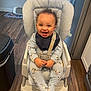 Jayce is registered to the contest to win money with this photo: baby, high_chair, smiling, indoor, child, pajamas, bib, zebra_pattern, curly_hair, wooden_floor, kitchen, window, natural_light, happy, seat_belt, infant, furniture, young_child, person, flooring