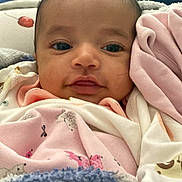 Aruna is registered to the contest to win money with this photo: baby, infant, face, blanket, clothing, close_up, cute, eyes, expression, fabric, head, indoors, infant_clothing, laying_down, looking_at_camera, person, portrait, soft_texture, smile, wrapped