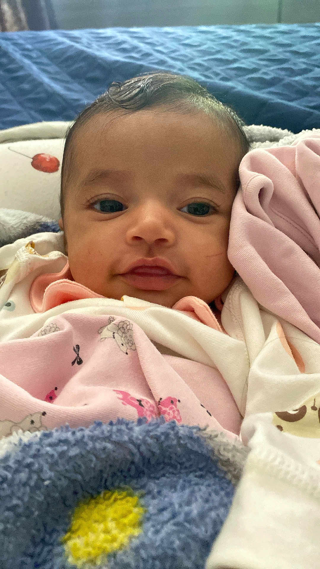 Aruna is registered to the contest to win money with this photo: baby, infant, face, blanket, clothing, close_up, cute, eyes, expression, fabric, head, indoors, infant_clothing, laying_down, looking_at_camera, person, portrait, soft_texture, smile, wrapped