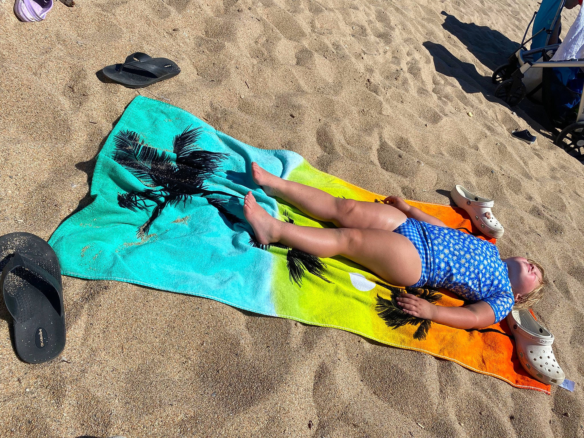 Scarlett is registered to the contest to win money with this photo: beach, electric_blue, eyewear, fun, human_leg, knee, landscape, leg, leisure, pattern, people_in_nature, person, public_event, recreation, sand, shadow, shoe, shorts, sitting, sun_tanning