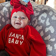 Sophia is registered to the contest to win money with this photo: baby, smile, red_clothing, headband, bow, blanket, indoor, happy, infant, face, sweater, child, cute, holiday, portrait, cozy, person, apparel, pattern, soft