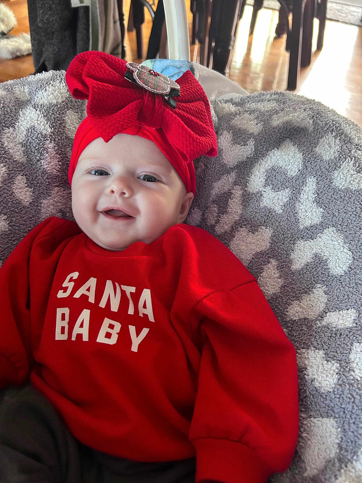 Sophia is registered to the contest to win money with this photo: baby, smile, red_clothing, headband, bow, blanket, indoor, happy, infant, face, sweater, child, cute, holiday, portrait, cozy, person, apparel, pattern, soft