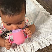 Kaylani is registered to the contest to win money with this photo: baby, child, pink_sippy_cup, blanket, frills, wooden_floor, toy, colorful_toy, indoor, crawling, hand, face, eyelashes, clothing, infant, cute, playtime, floor, focus, toddler