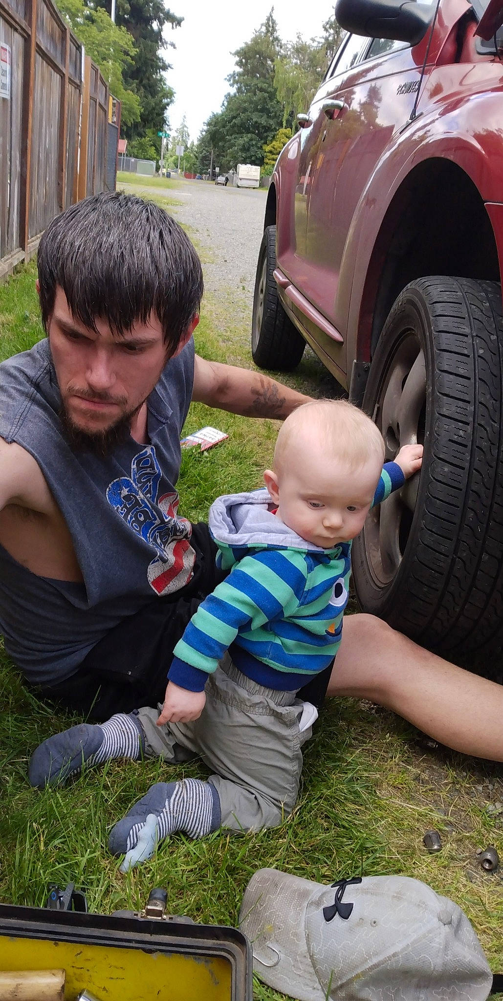John joined the competition — help win amazing prizes! automotive_exterior, automotive_tire, car, child, fender, grass, land_vehicle, lap, leisure, people, person, plant, shorts, sneakers, summer, tire, toddler, tree, vehicle, vehicle_door
