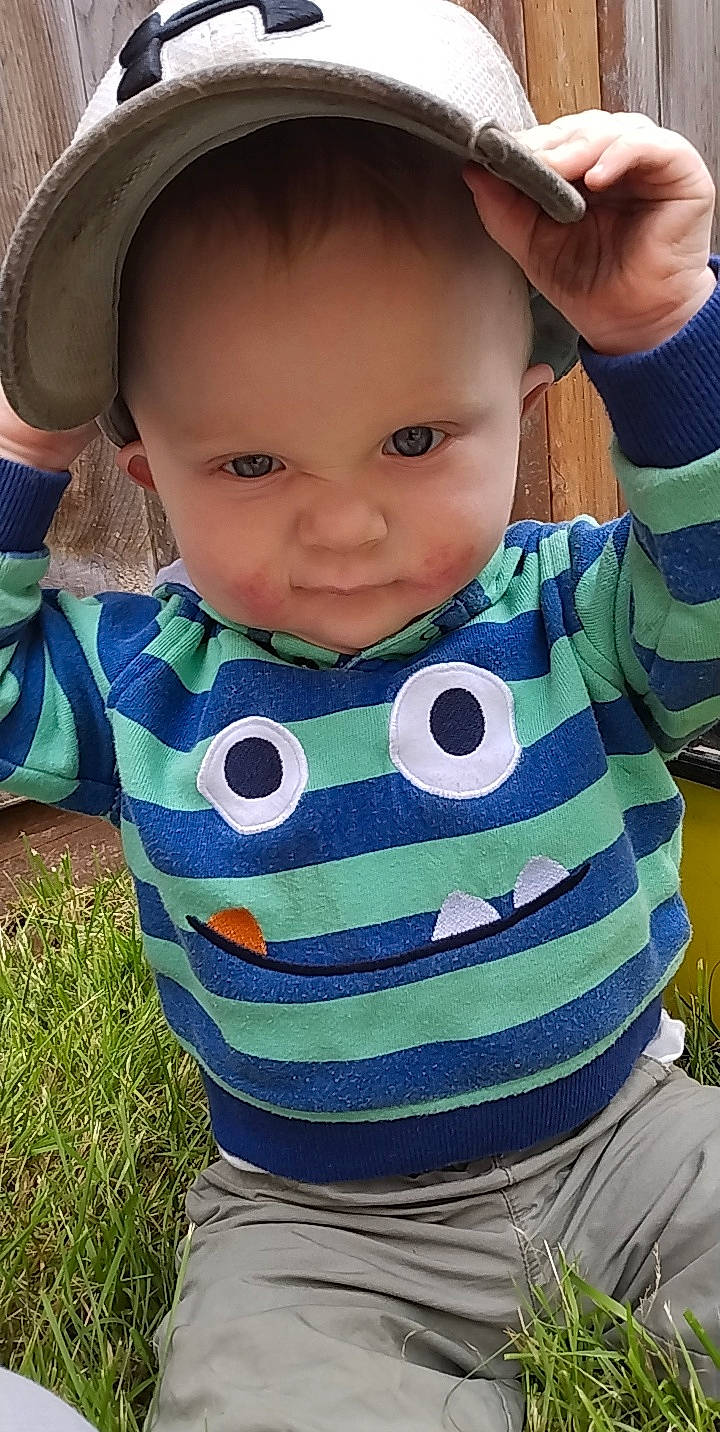 John is registered to the contest to win money with this photo: azure, baby_toddler_clothing, cheek, eye, eyelash, face, gesture, grass, head, iris, lip, mouth, neck, nose, outerwear, person, product, skin, sleeve, standing