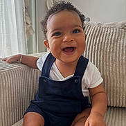 Lyham participe au concours pour gagner de l'argent avec cette photo : baby, bright_eyes, child, comfortable, couch, curly_hair, cute, expression, face, foot, hand, happy, indoors, infant, overalls, portrait, sitting, skin, smiling, white_shirt