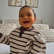 Lyham participe au concours pour gagner de l'argent avec cette photo : baby, smiling, striped_sweater, child, indoor, bed, pillows, abstract_art, happy, cute, portrait, person, young_child, cozy, knitwear, infant, room, home, sitting, face