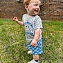toddler, child, grass, outdoor, smiling, happy, red_hair, shorts, tshirt, shoes, sneakers, nature, flower, greenery, portrait, person, cute, playful, young_child, daylight