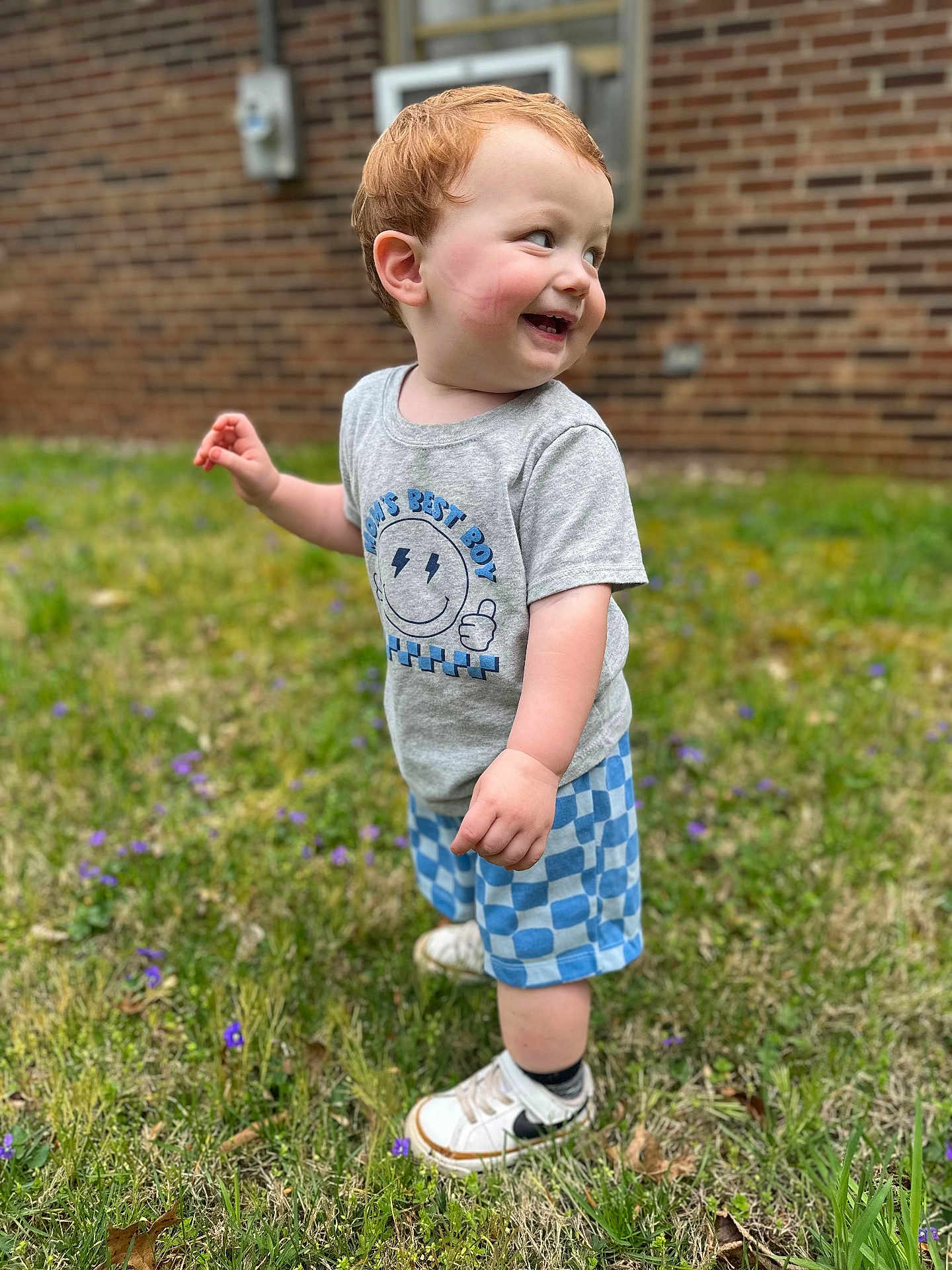 Dawson joined the competition — help win amazing prizes! toddler, child, grass, outdoor, smiling, happy, red_hair, shorts, tshirt, shoes, sneakers, nature, flower, greenery, portrait, person, cute, playful, young_child, daylight