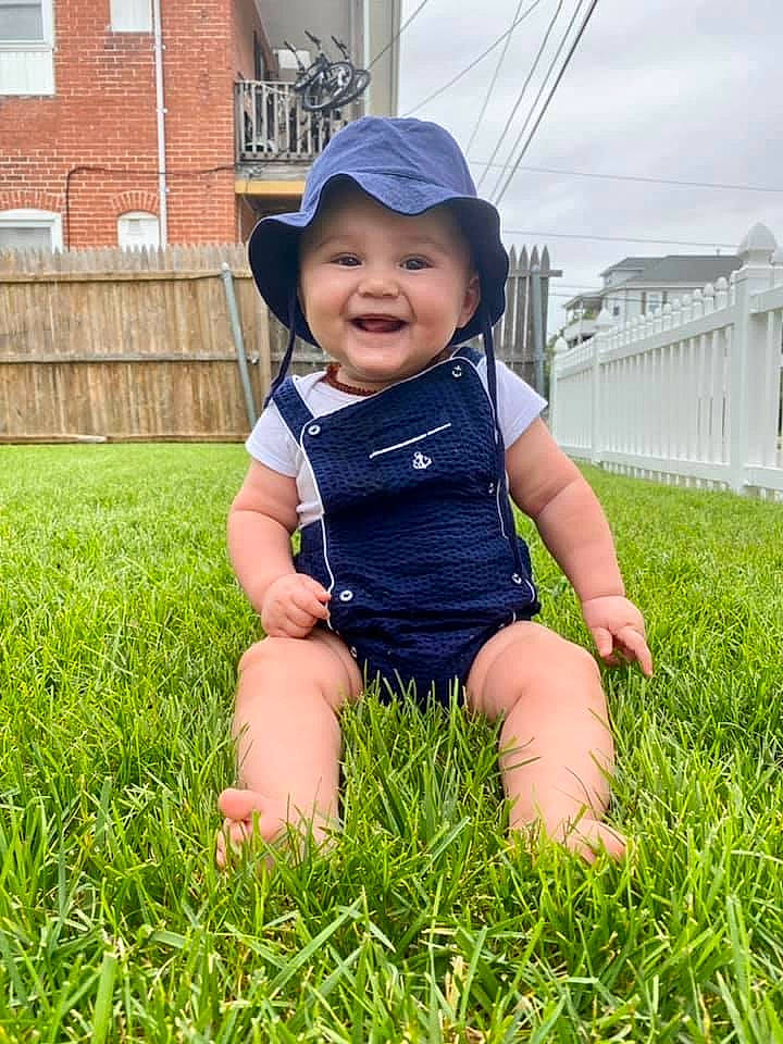 Atilla is registered to the contest to win money with this photo: baby, baby_toddler_clothing, cap, face, flash_photography, fun, grass, grassland, happy, hat, headwear, joy, lawn, leisure, meadow, people_in_nature, person, plant, smile, sun_hat