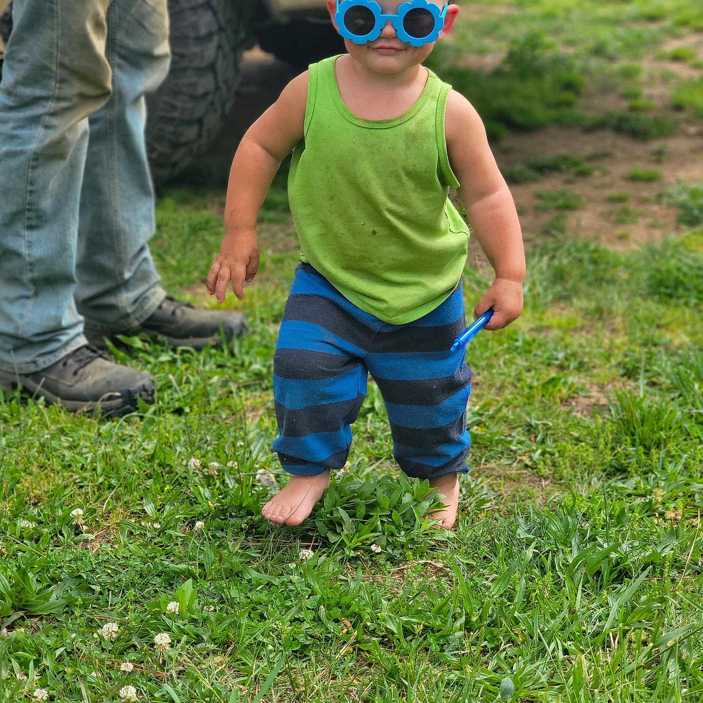 Dane joined the competition — help win amazing prizes! toddler, child, barefoot, grass, blue_sunglasses, green_tank_top, striped_pants, outdoor, person, adult, jeans, boots, dirt, toy, summer, nature, cute, portrait, fun, playful