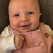 Jade a rejoint le concours — aidez-le/la à gagner de superbes lots ! baby, infant, smile, close_up, portrait, overalls, pink, corduroy, hand, eyes, couch, fabric, button, cheek, skin, newborn, cute, clothing, seat, one_person