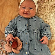 Jade participe au concours pour gagner de l'argent avec cette photo : baby, blanket, bow, child, chubby_cheeks, cozy, cute, denim_dress, fabric, hand, headband, heart_pattern, indoors, infant, lying_down, plush_toy, portrait, smile, soft_texture, towel