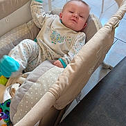 Deven participe au concours pour gagner de l'argent avec cette photo : baby, playpen, onesie, polka_dot, cushion, toy, floor, tile, child, indoor, relaxing, sleepy, clothing, footwear, person, furniture, baby_bed, infant, cute, home