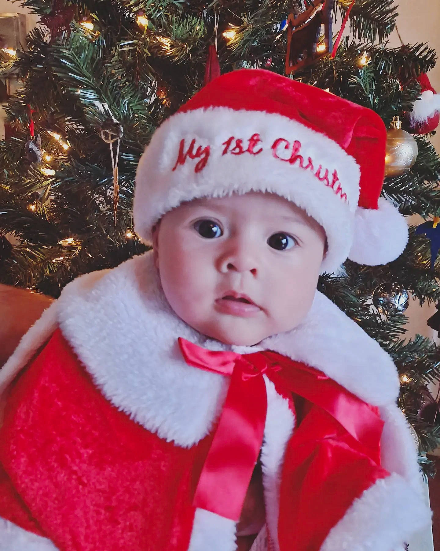 Lena joined the competition — help win amazing prizes! baby_toddler_clothing, beauty, christmas_decoration, christmas_ornament, christmas_tree, costume_hat, event, face, facial_expression, happy, head, headgear, headwear, holiday, holiday_ornament, human_body, ornament, outerwear, person, sleeve