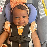 Dayalani is registered to the contest to win money with this photo: baby, child, car_seat, seatbelt, bow, headband, smile, cute, infant, clothing, sitting, child_safety, portrait, happy, young, person, closeup, indoor, car, seat