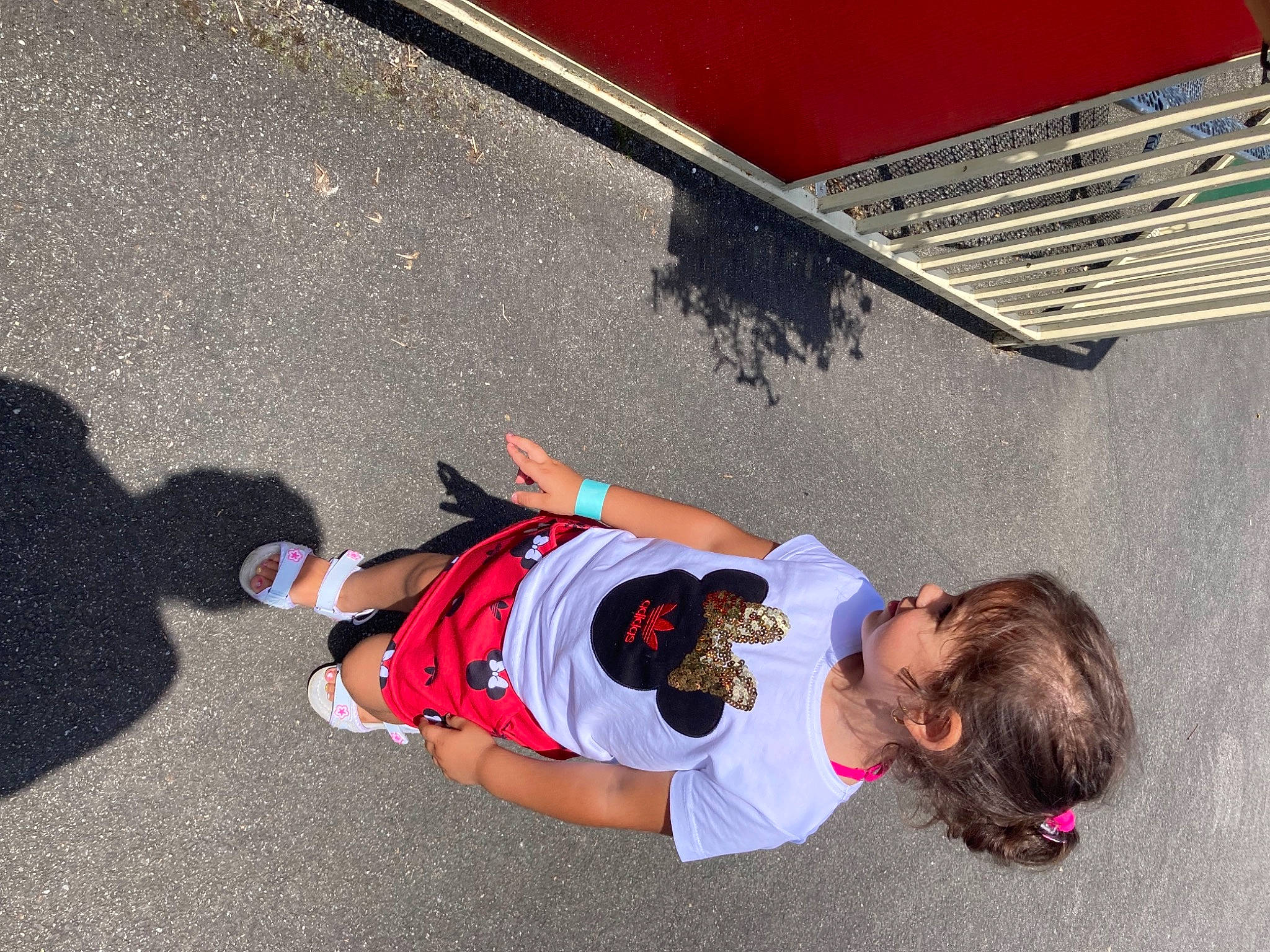 Carolina participe au concours pour gagner de l'argent avec cette photo : asphalt, bumper, child, concrete, fun, grass, hat, human_leg, leisure, person, play, road_surface, shadow, sitting, t_shirt, toddler, wall