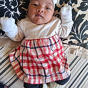 Rosèminá is registered to the contest to win money with this photo: baby, infant, child, headband, mittens, dress, knitted_booties, bedspread, pattern, black_and_white, red, white, striped, floral, lying_down, cute, portrait, indoors, cozy, calm