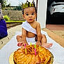 baby, toddler, crown, cake, candles, birthday, outdoor, blanket, sash, diaper, surprised_expression, pastry, golden_plate, garage, car, driveway, garden_wall, sitting, barefoot, celebration