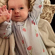 Emersyn is registered to the contest to win money with this photo: baby, blanket, child, comfort, cozy, cute, expression, face, floral, hand, indoor, infant, lying_down, newborn, onesie, person, pink, skin, sleepwear, soft