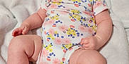 Emersyn is registered to the contest to win money with this photo: arms, baby, blanket, child, clothing, cute, expression, face, feet, floral_pattern, indoor, infant, legs, newborn, onesie, person, portrait, relaxing, skin, soft_texture