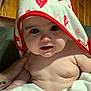 baby, child, towel, hood, hearts, skin, hand, tattoo, wooden_wall, indoor, curious, chubby_cheeks, face, portrait, infant, cute, human, person, closeup, soft_lighting