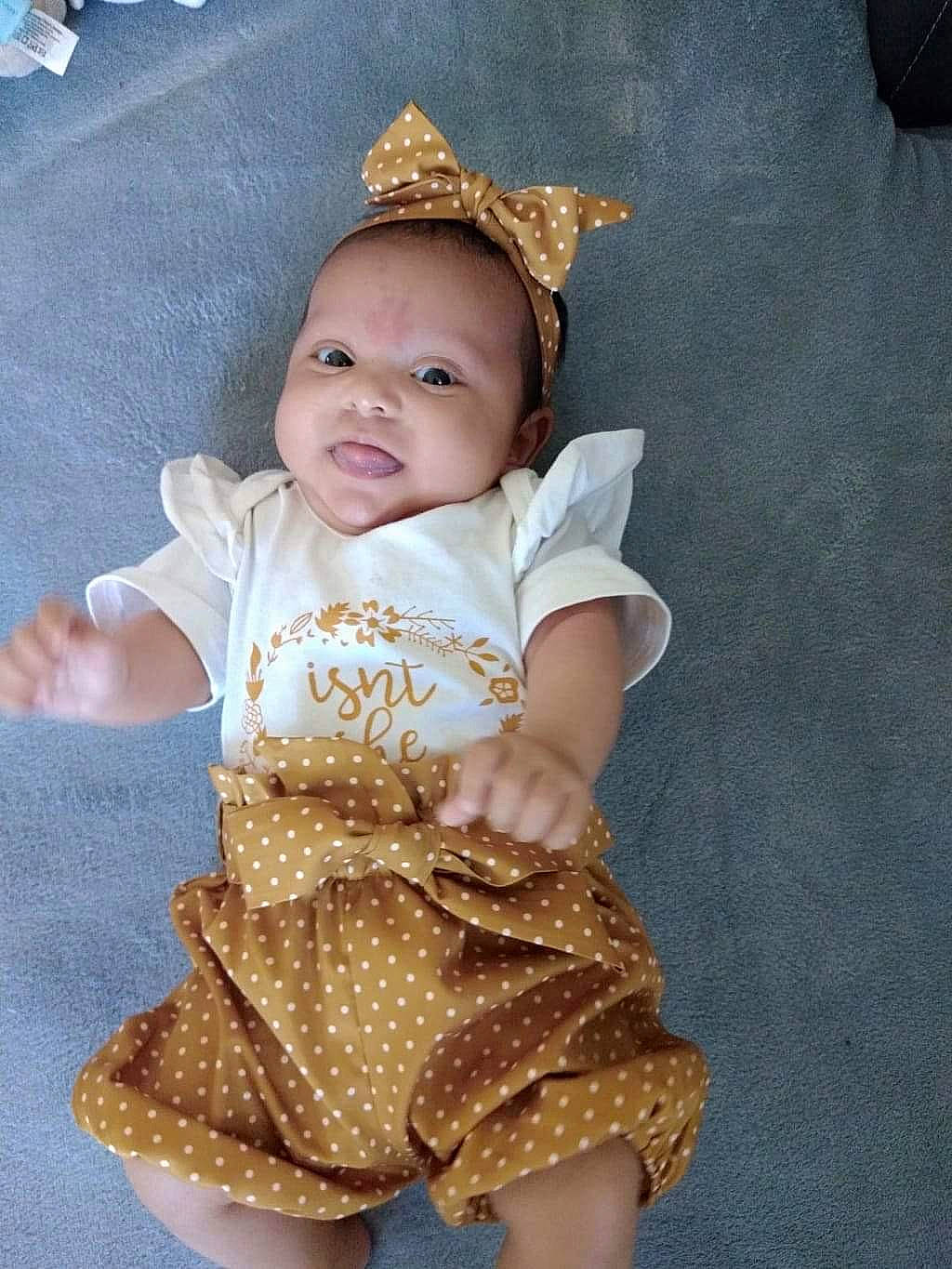 May-lee a rejoint le concours — aidez-le/la à gagner de superbes lots ! baby, baby_toddler_clothing, cheek, child, chin, costume_hat, eye, flooring, fun, happy, head, headgear, iris, pattern, person, pink, skin, sleeve, standing, t_shirt