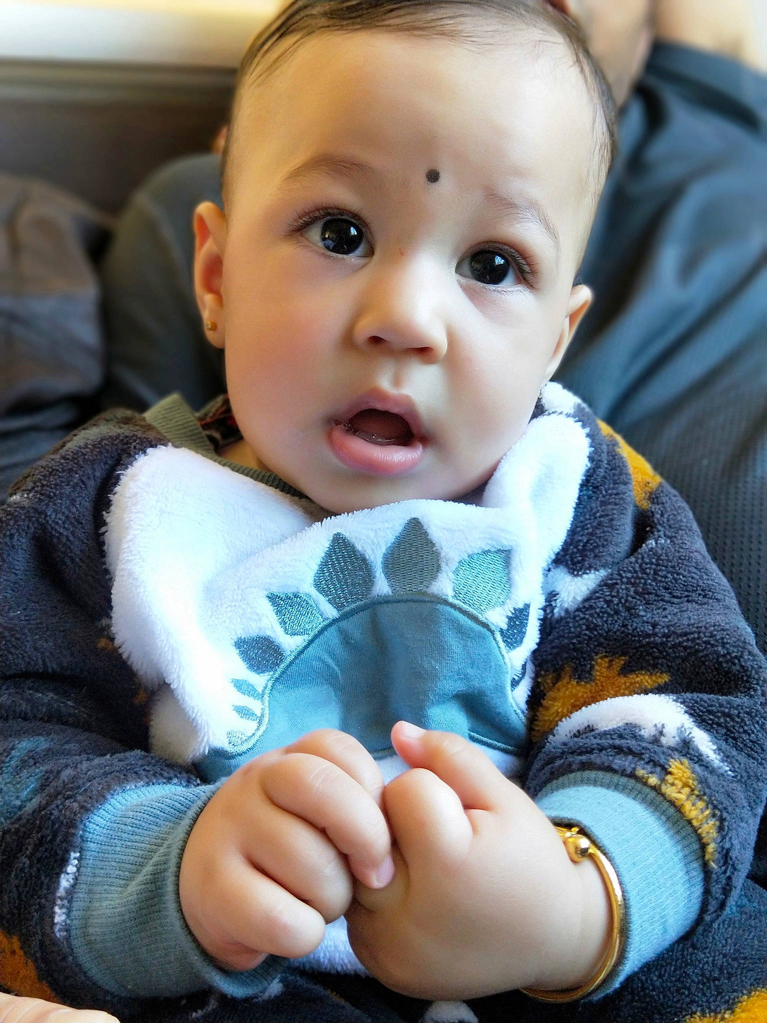 Reyansh is registered to the contest to win money with this photo: baby, cheek, child, chin, eye, face, facial_expression, finger, hand, head, iris, leg, lip, mouth, nose, person, sitting, skin, smile, surprise