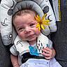 baby, baby_seat, blanket, blue_eyes, brown_hair, child, close_up, clothing, cushion, face, flower, hand, happy, indoor, infant, pacifier, portrait, sitting, smiling, textile