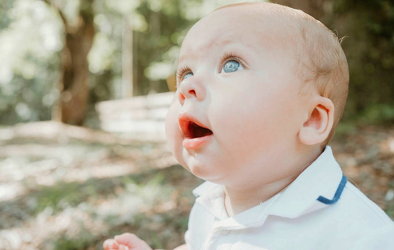 Logan is registered to the contest to win money with this photo: baby, baby_toddler_clothing, cheek, child, collar, dress, event, flash_photography, fun, grass, happy, iris, nose, people_in_nature, person, plant, portrait_photography, skin, smile, surprise