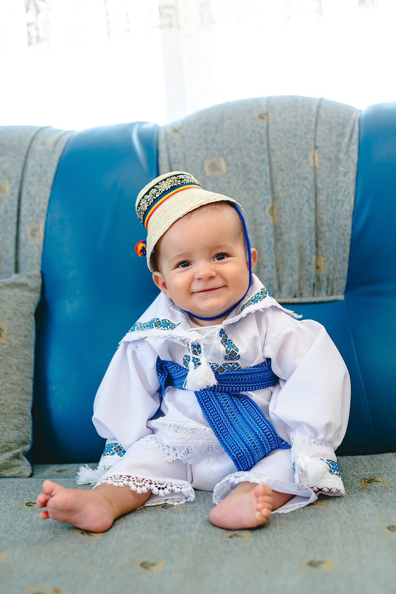 Dominic participe au concours pour gagner de l'argent avec cette photo : armrest, baby, baby_laughing, baby_toddler_clothing, blue, bonnet, child, comfort, couch, eye, human_body, joy, living_room, mouth, nose, person, sitting, slipcover, teal, textile