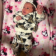 Elliana is registered to the contest to win money with this photo: baby, newborn, infant, headband, bow, minnie_mouse, blanket, pink, pattern, pacifier, outfit, gaze, hand, arm, legs, booties, crib, soft_fabric, cute, portrait
