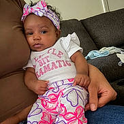 Khylie joined the competition — help win amazing prizes! baby, infant, child, headband, floral_pattern, colorful_clothing, couch, furniture, hand, adult, portrait, indoor, casual, resting, curious, sitting, pink, purple, white, toddler