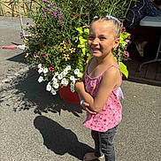 Ilouna participe au concours pour gagner de l'argent avec cette photo : child, girl, barefoot, braids, colorful_hair, pink_top, jeans, flower_pot, flowers, outdoor, sunlight, shadow, smile, pavement, person, elderly, table, chair, greenery, nature