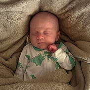 Gwyneth joined the competition — help win amazing prizes! baby, sleeping, blanket, onesie, dinosaur, cozy, infant, child, soft, cute, resting, bedtime, warm, comfort, portrait, peaceful, indoors, sleep, newborn, face