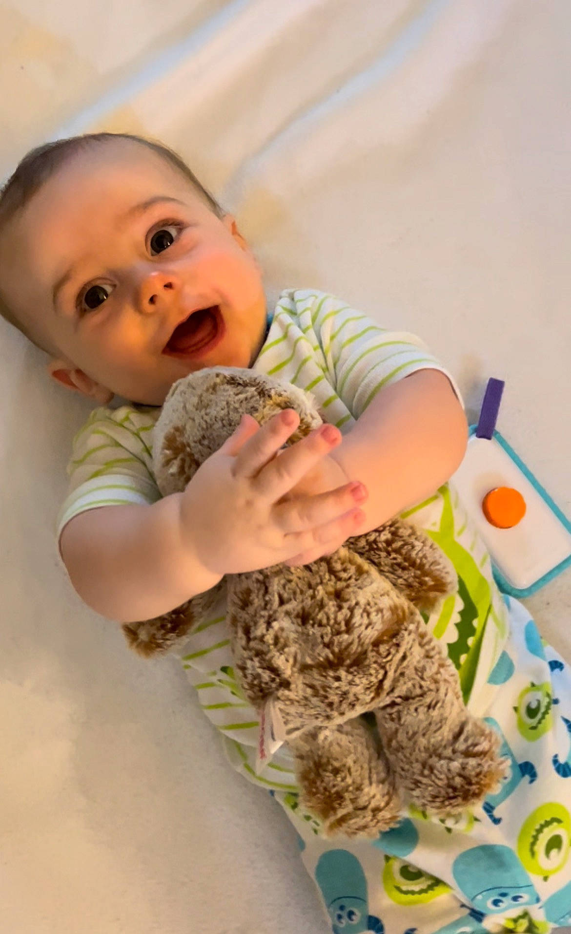 Reece is registered to the contest to win money with this photo: arm, baby, baby_toddler_clothing, child, comfort, finger, flooring, fun, gesture, happy, joint, pattern, person, play, room, sleeve, stuffed_toy, t_shirt, thumb, toddler